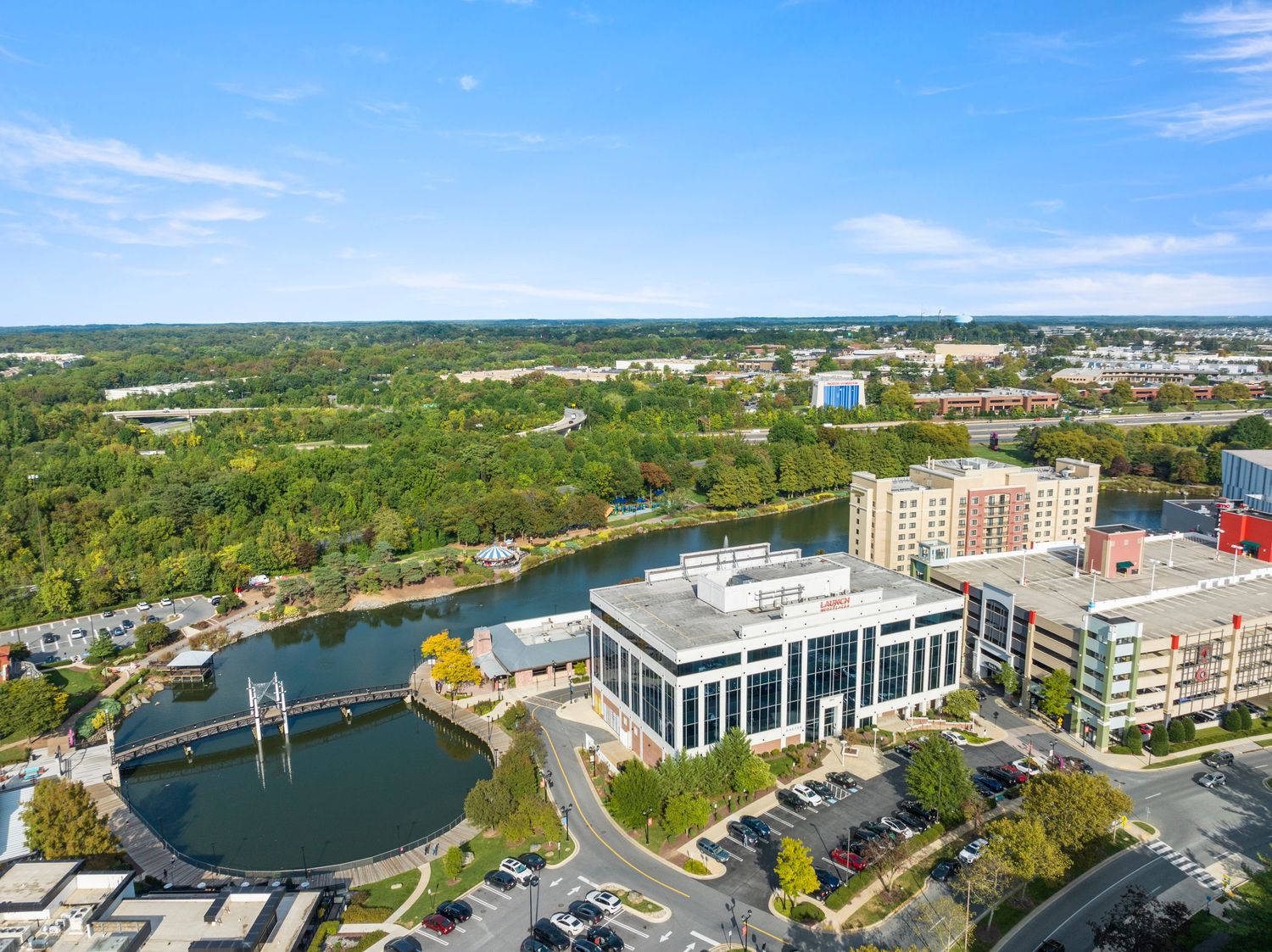 Aerial view of modern buildings and bridges along a winding river in an urban setting.