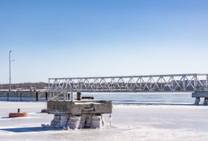Frozen harbor landscape with wooden piers extending over ice-covered water.