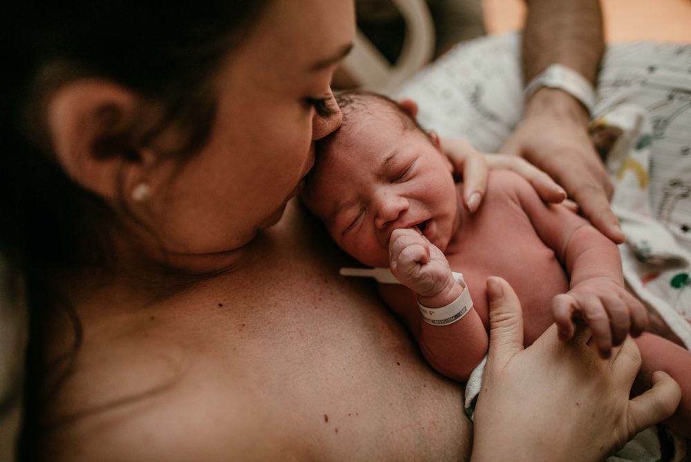 mother holds infant hospital birth photography portland oregon