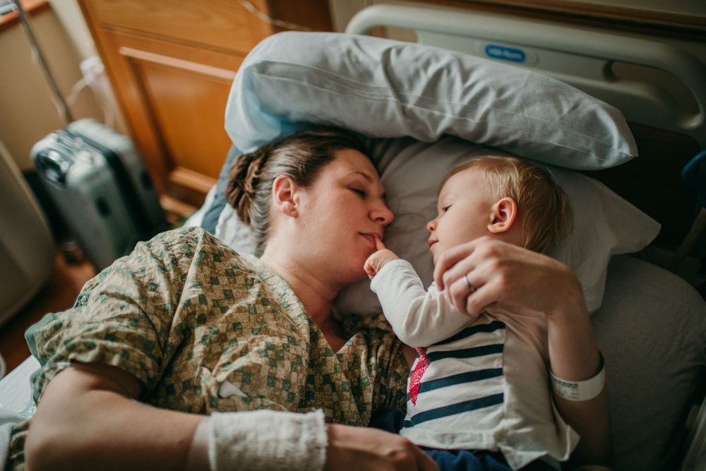 white mother and child in hospital bed during labor birth photographer portland oregon