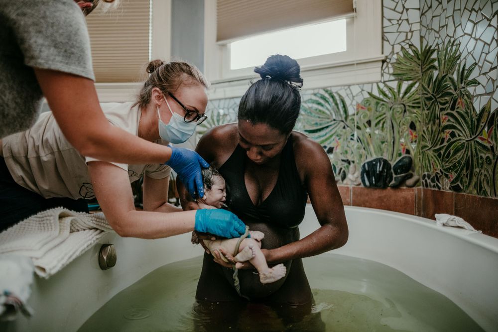 black mother holds baby after water birth at birth center portland oregon birth photographer