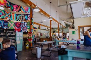 Colorful crafting workspace with tables and supplies arranged in a bright room.