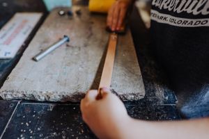Detailed crafting work being done on a dark surface.