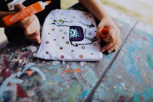 Art supplies and colorful drawings spread across a table during a creative activity session.