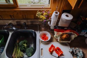 Fresh vegetables and cooking ingredients laid out on a kitchen counter for meal preparation.