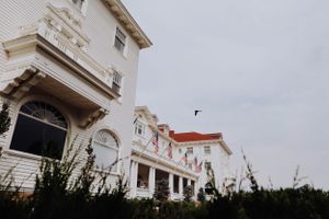 Architectural details of white colonial style building with ornate windows and arches.