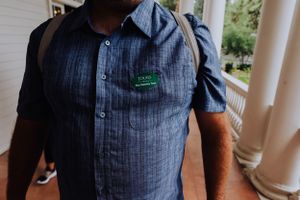 Close-up view of person wearing dark blue textured shirt with button details.