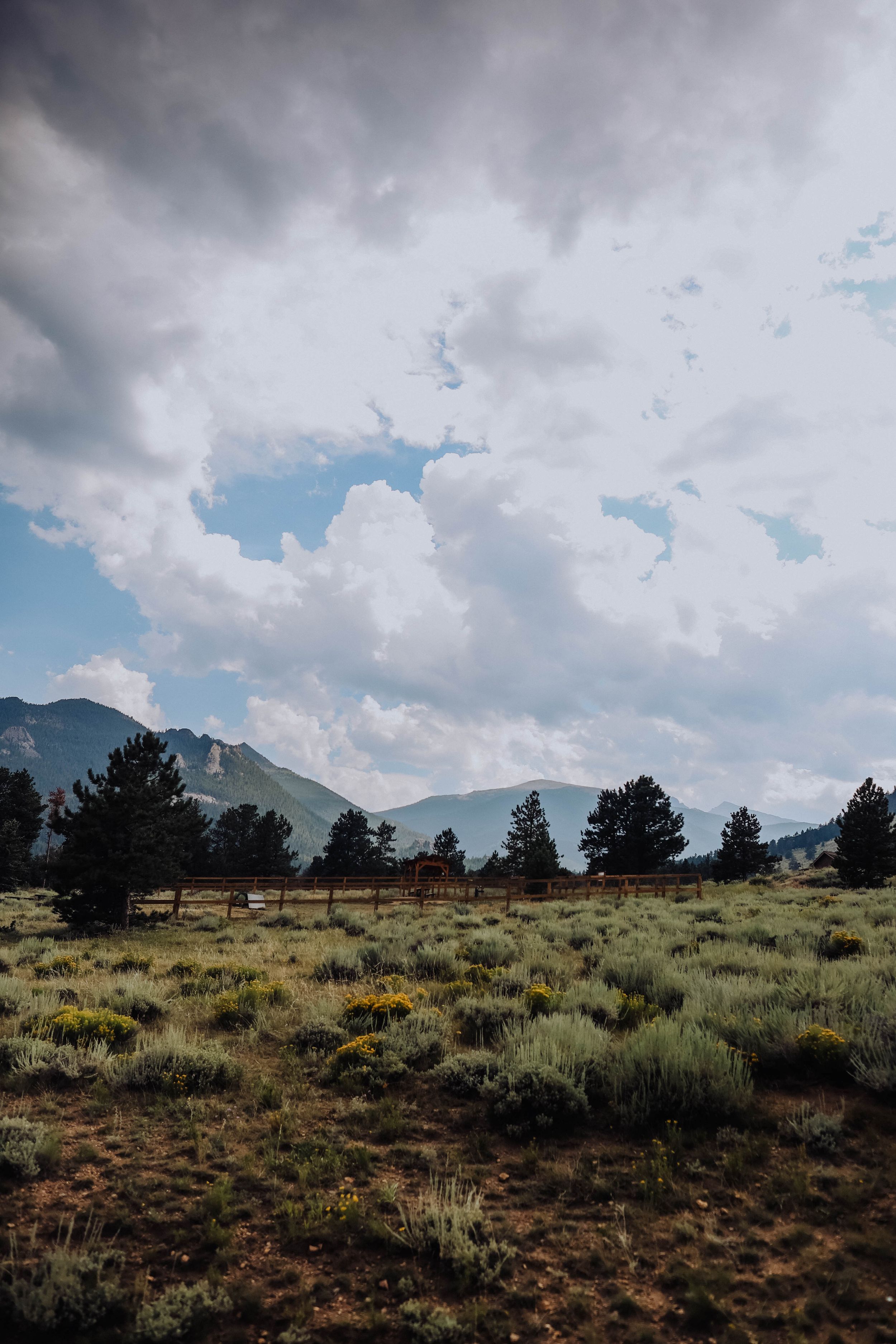 Dramatic storm clouds roll over mountain peaks and desert terrain.