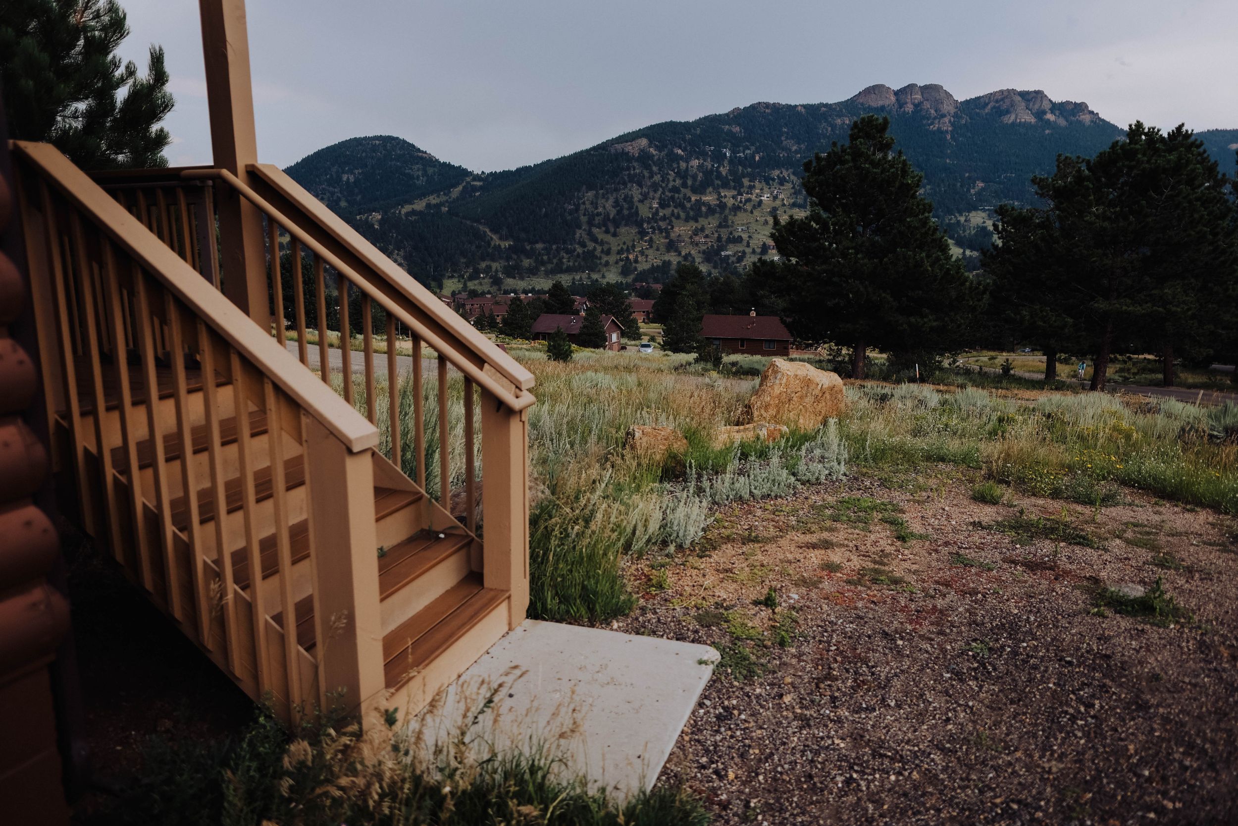 Wooden stairs lead up a hillside with mountains visible in the background.