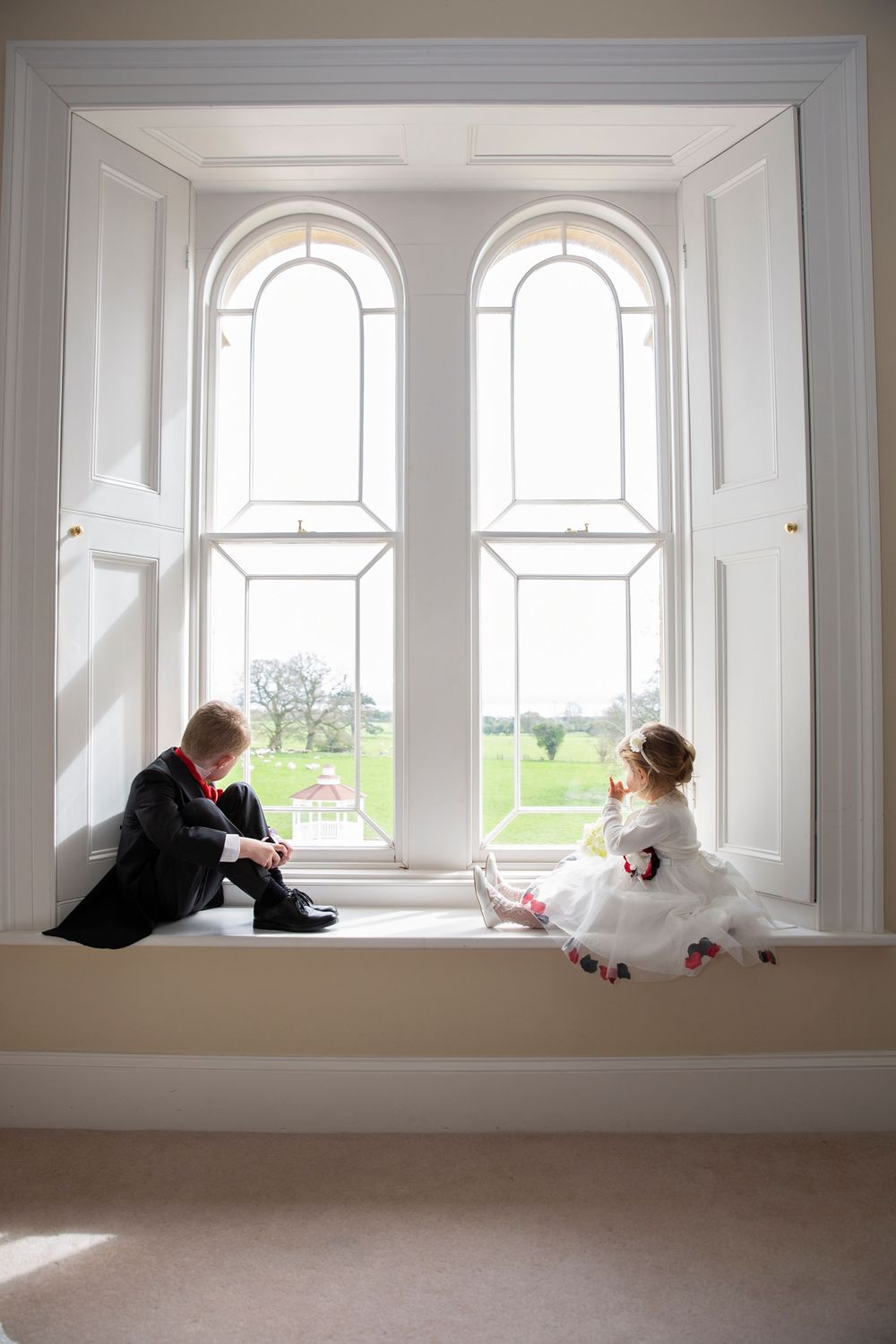 lovely moment page boy and flower girl sitting in the window at St Tewdrics House Chepstow