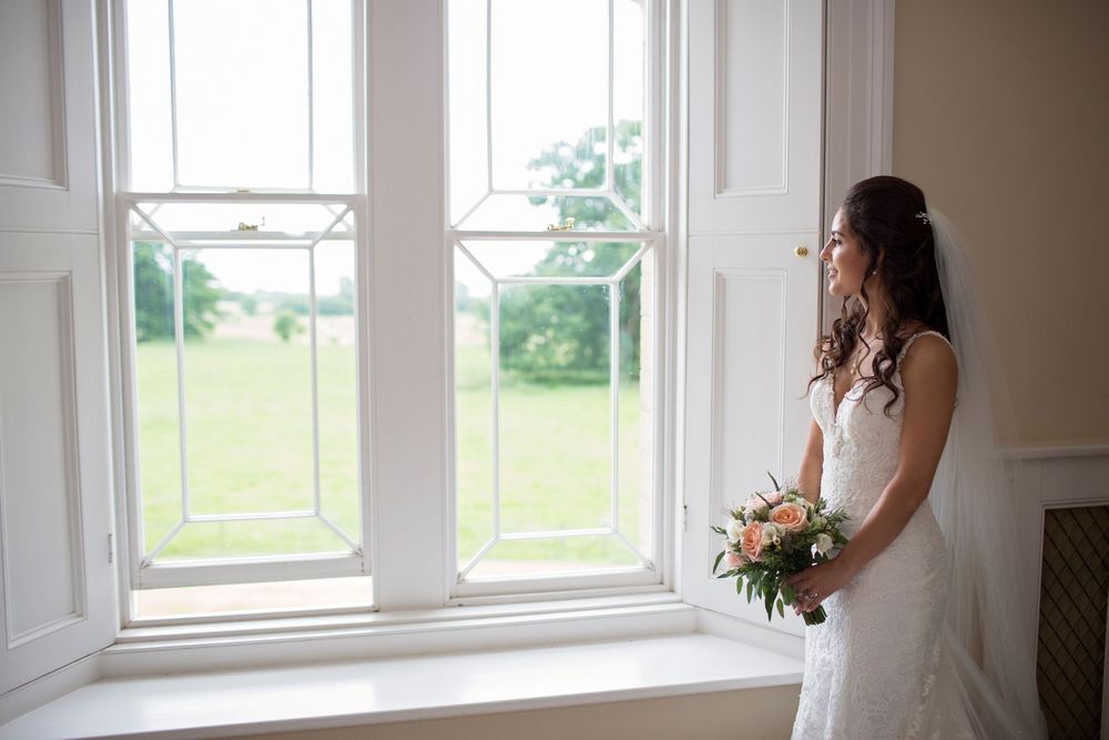 Bride gazing out window at St Tewdrics House