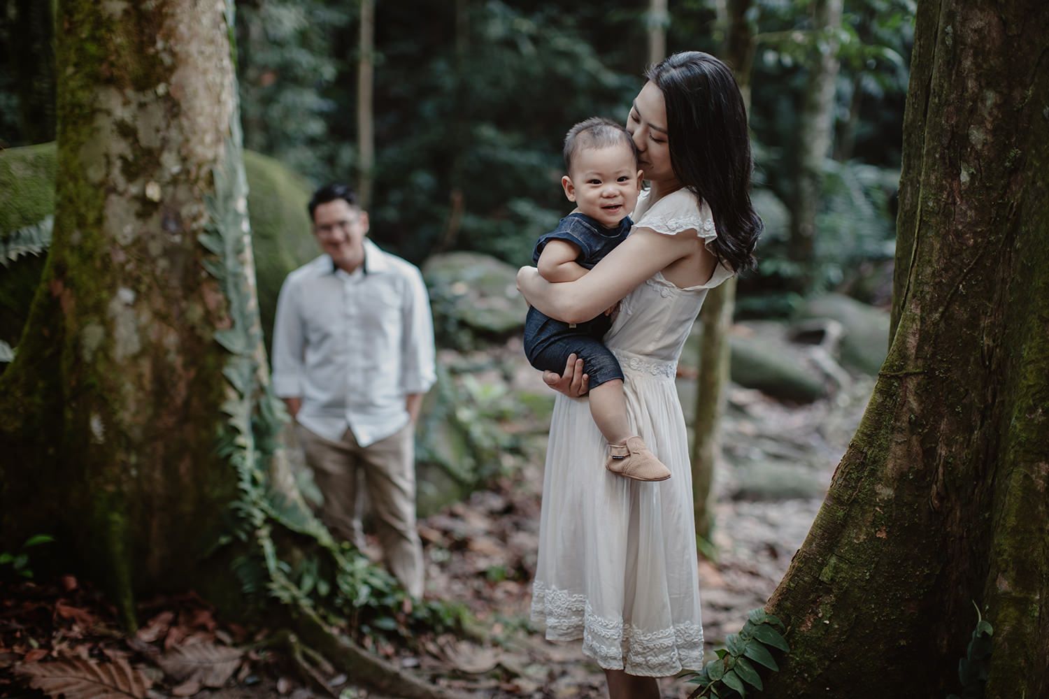 mother kissing her happy boy with father behind in the FRIM