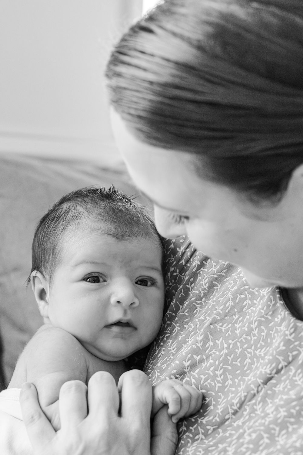 A tender black and white portrait showing a caring moment between mother and infant child.