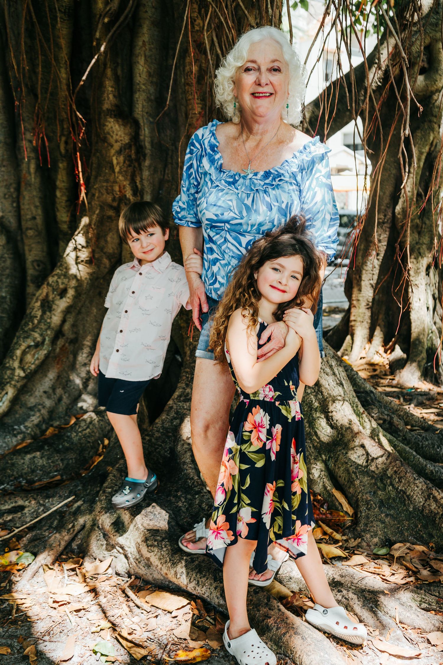 Outdoor Family Session in St. Pete, FL; Grandmother posing with grandkids near banyan trees