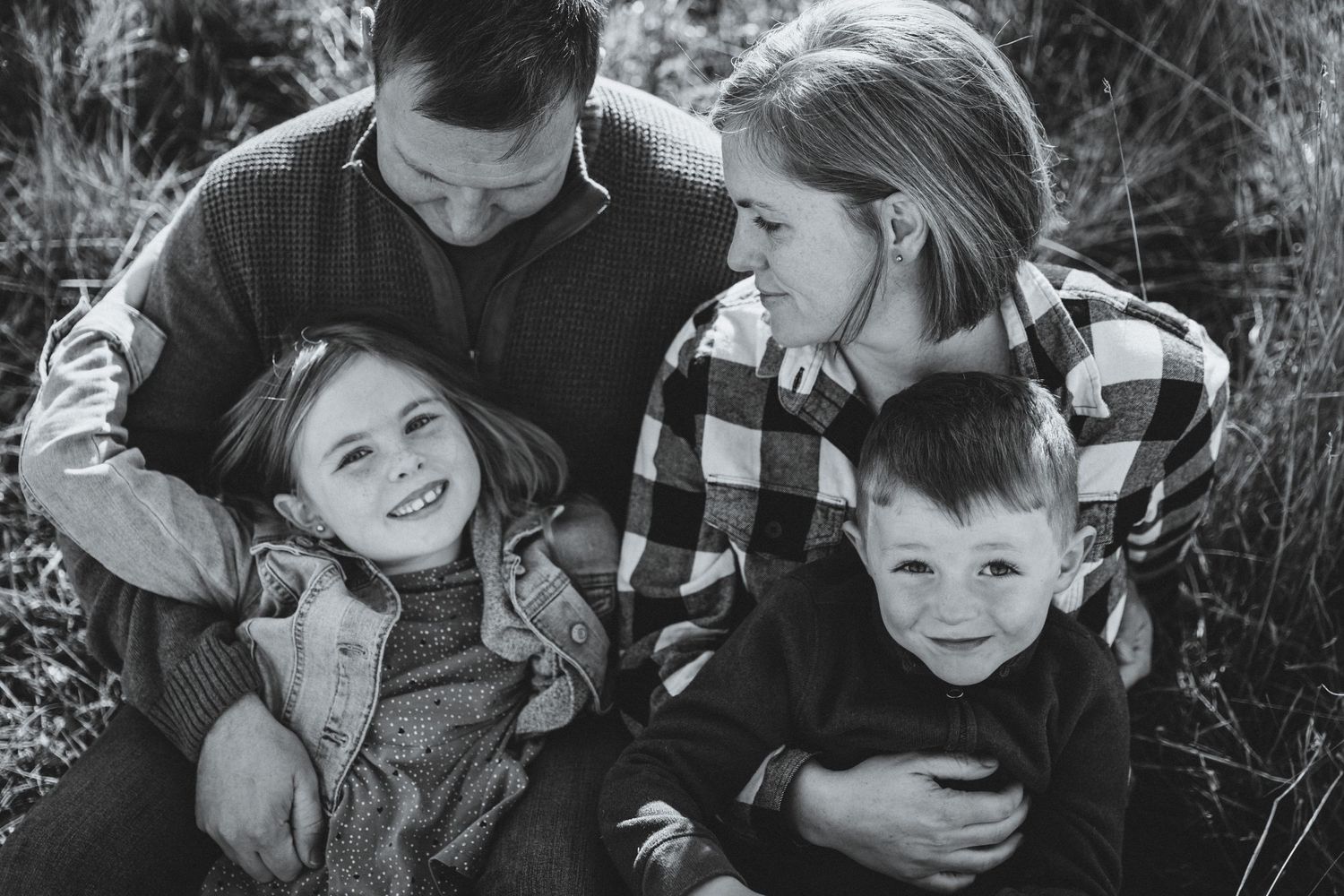 Dad tickles daughter while mom looks down at her lovingly