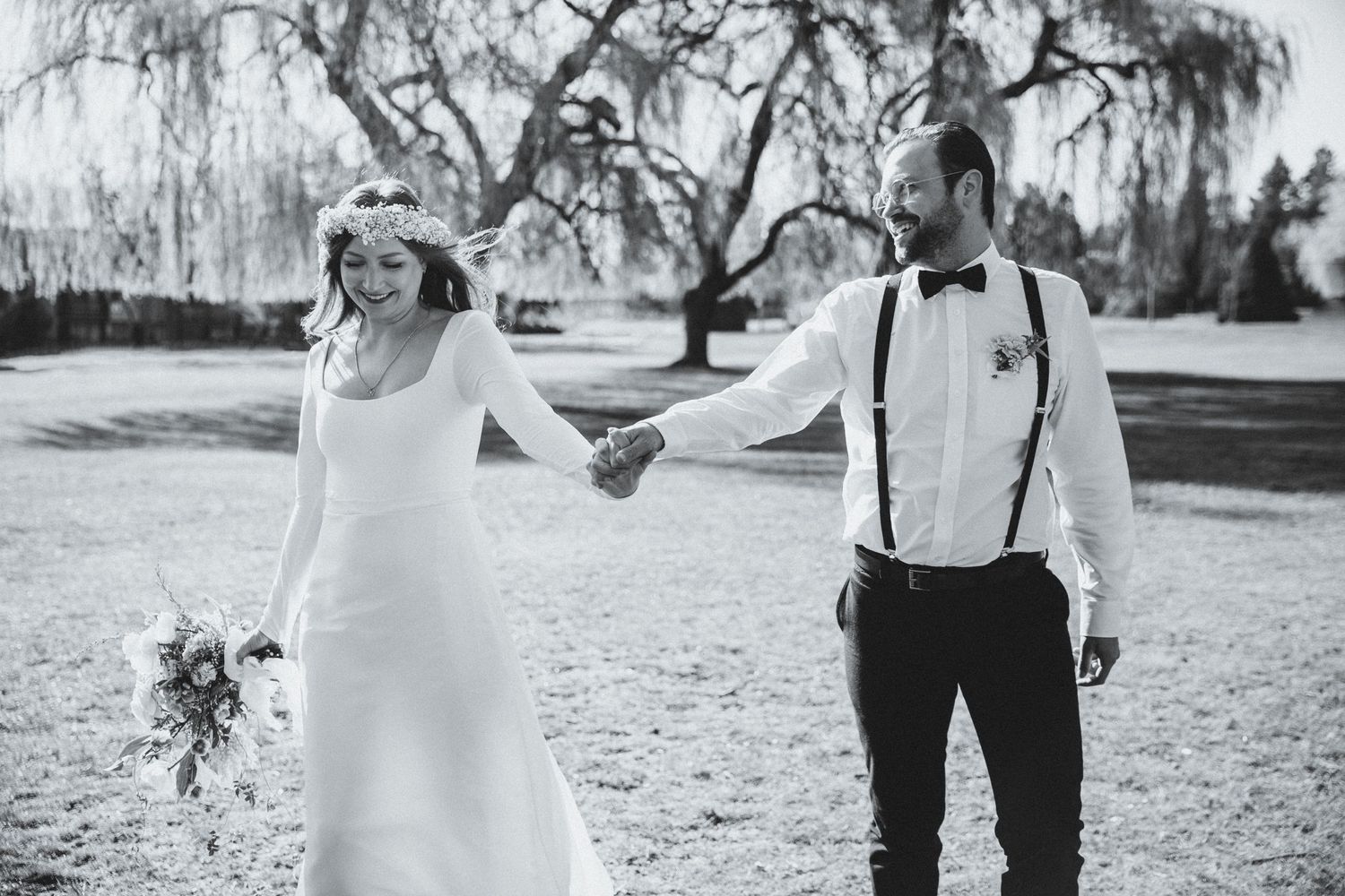 Bride and groom walk lovingly hand in hand
