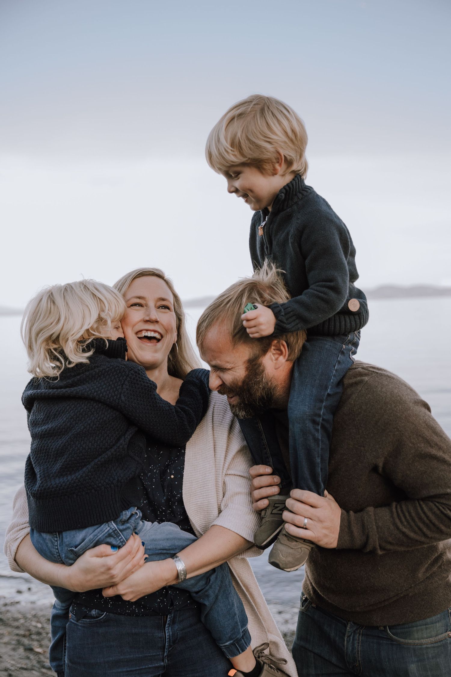 Family cuddles and giggles by the beach.