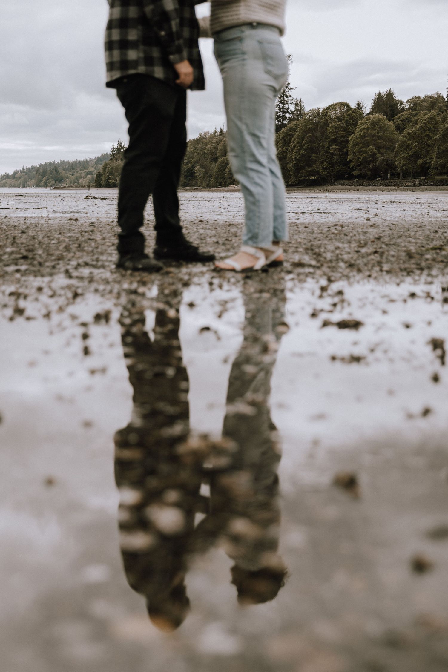 Reflection of couple in a puddle on the beach