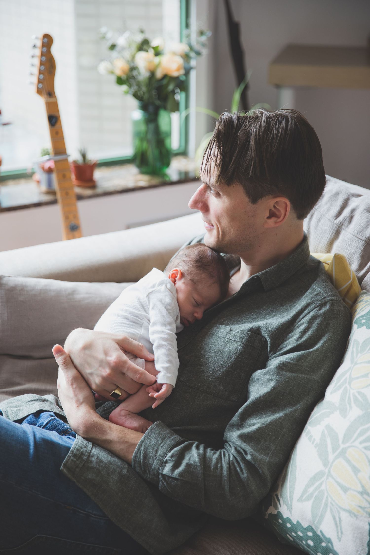 Newborn cuddles in dad's arms