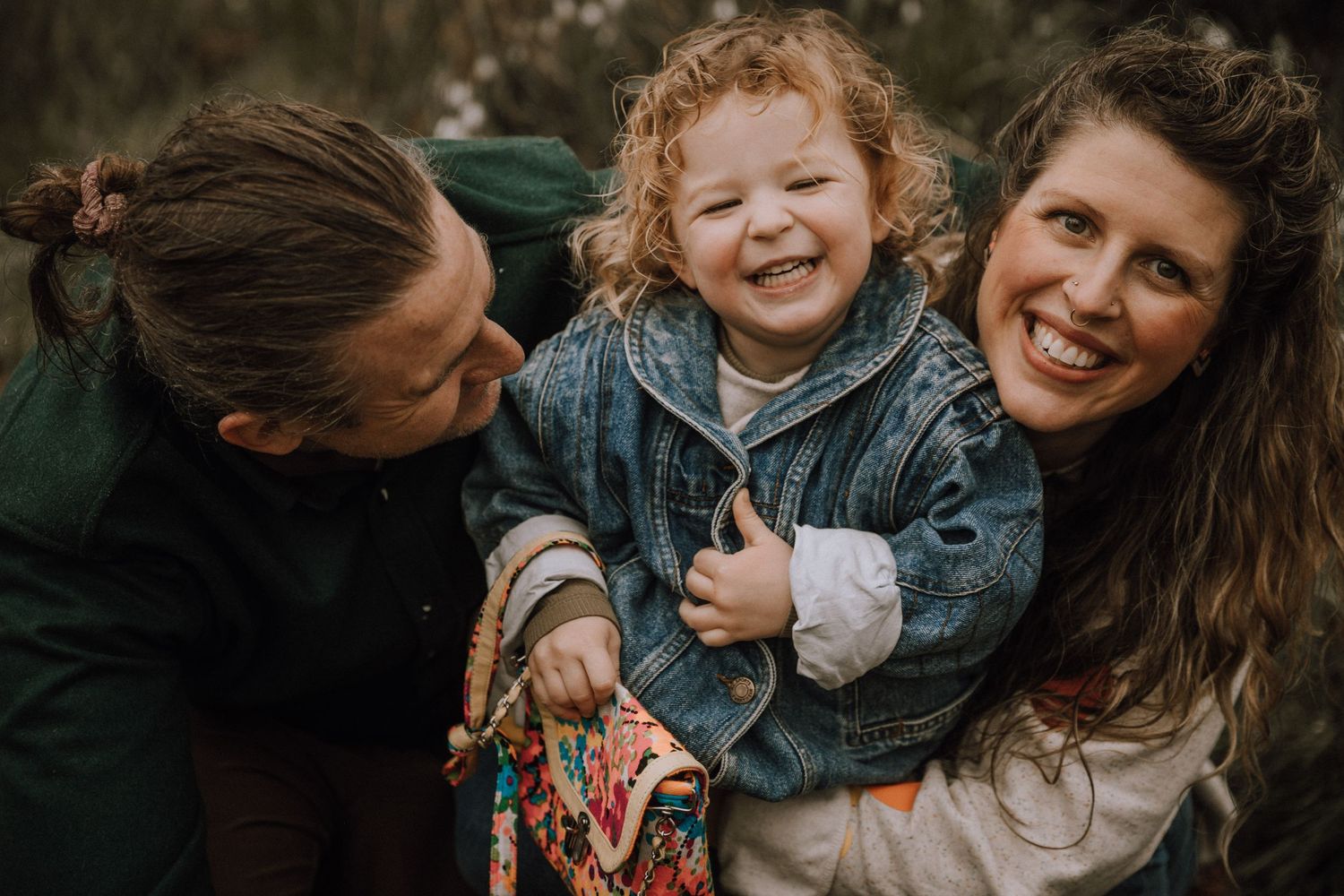Tickles for little girl while mom and dad cuddle her