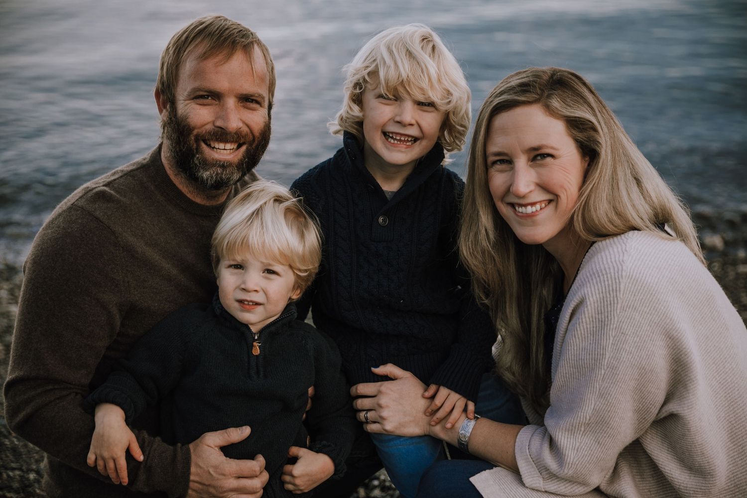 Family of four smiling on the beach