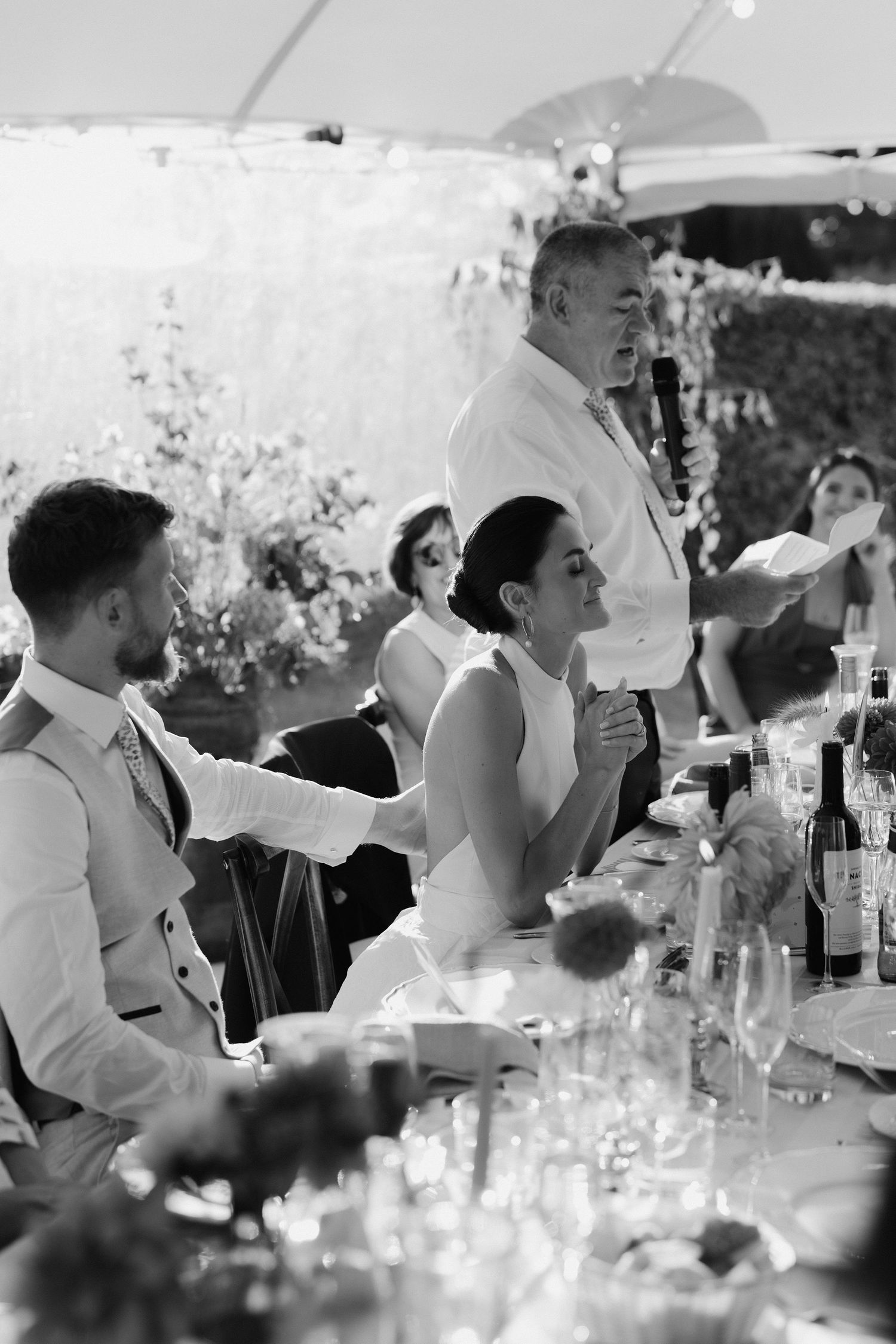 bride clasping hands together during emotional moment during father of the bride speech in islip in Oxfordshire