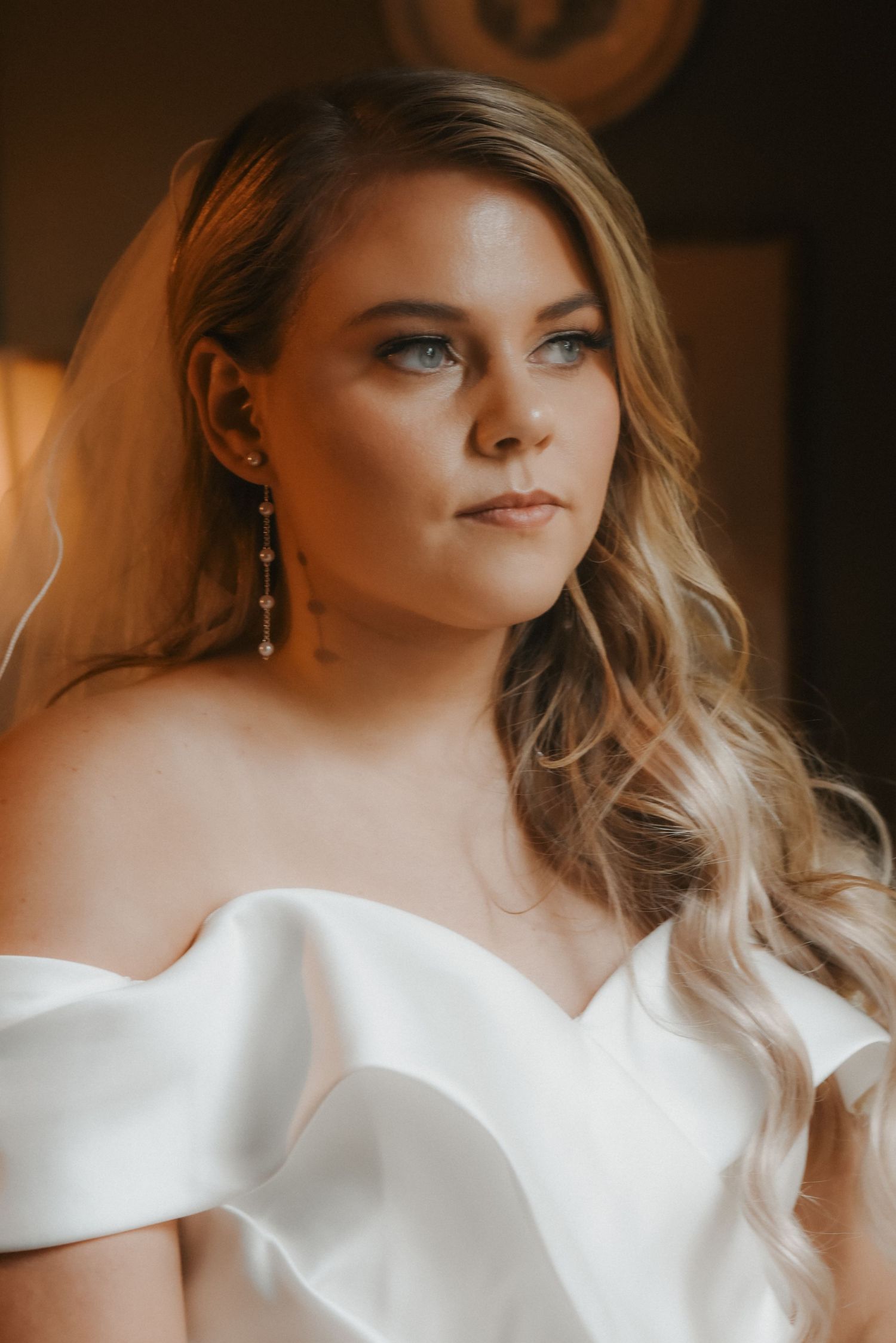 A wedding portrait featuring an elegant white dress and soft blonde waves hairstyle.