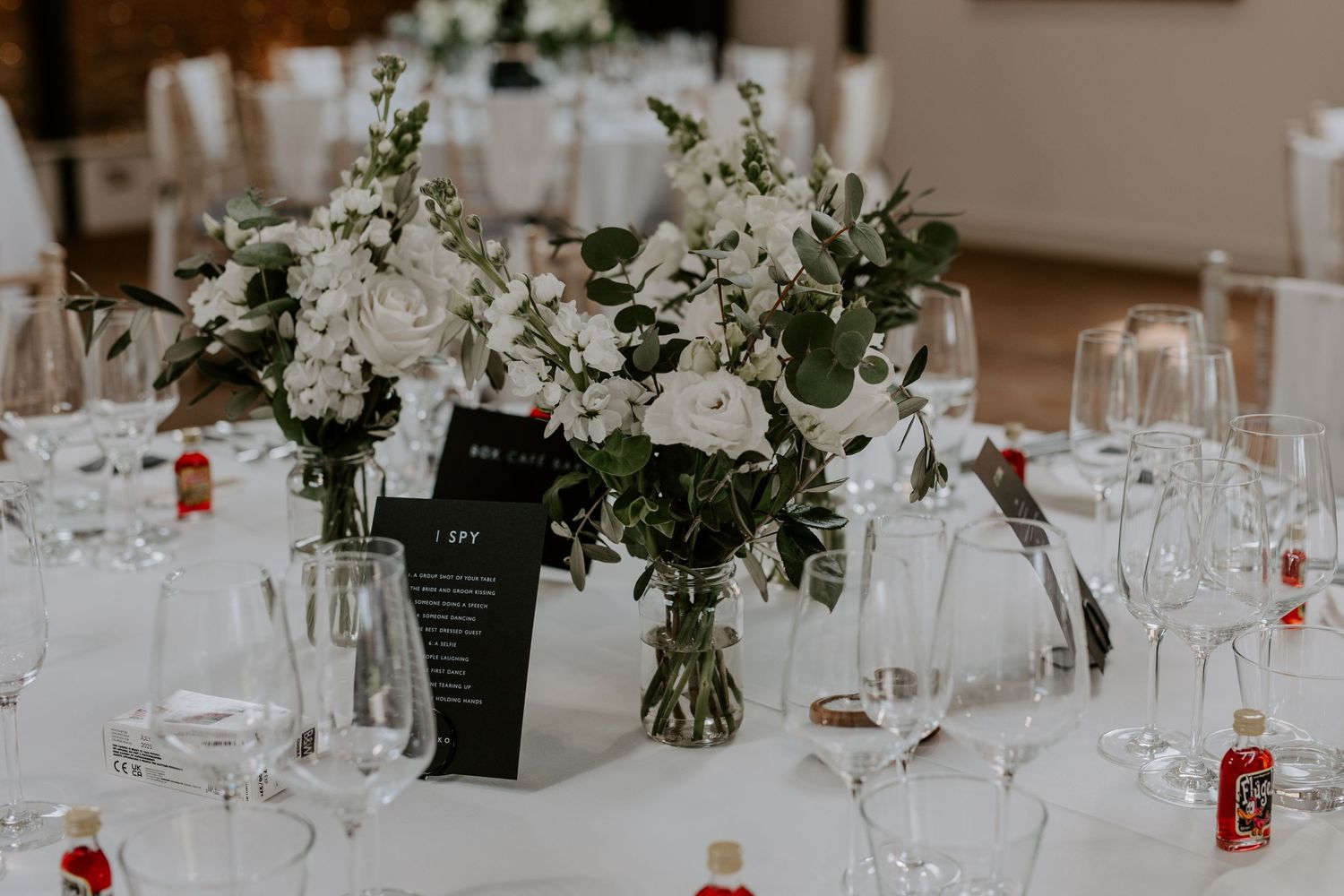 a close up photo of table decor. White roses in a glass vase.