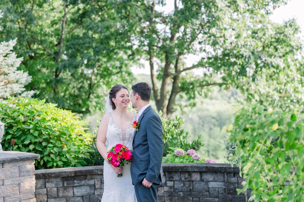 Wedding couple sharing an intimate moment on a stone terrace with scenic landscape views.