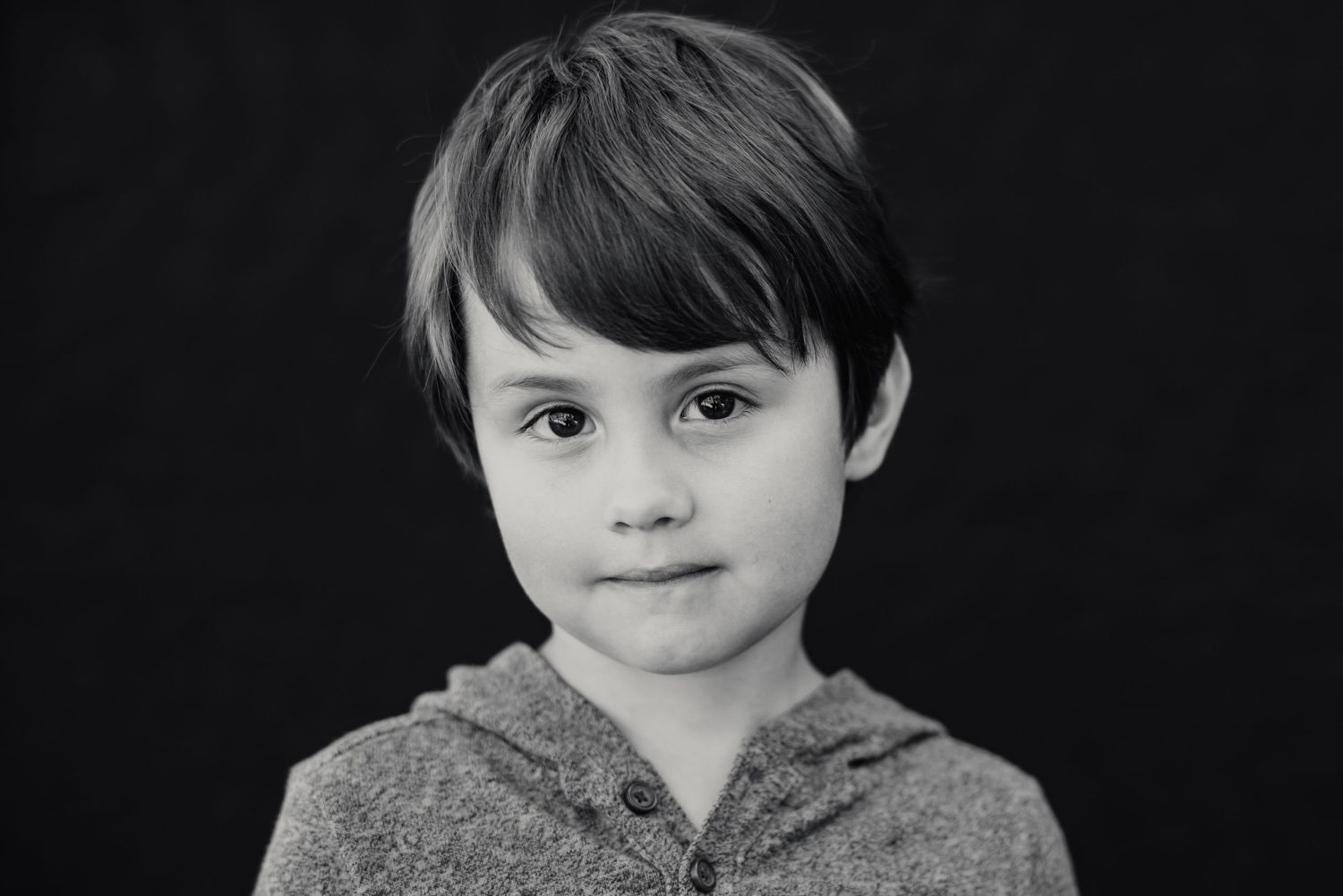 A monochrome headshot portrait of a young person in casual attire.