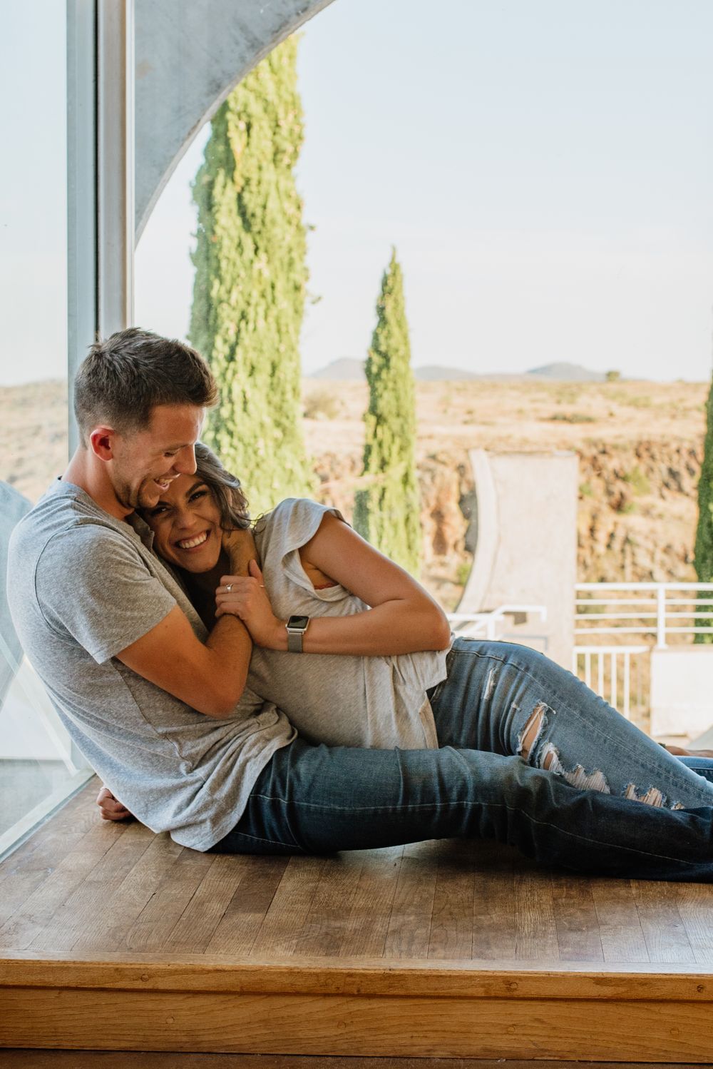 Couple lounging together on wooden platform with scenic mountain view.