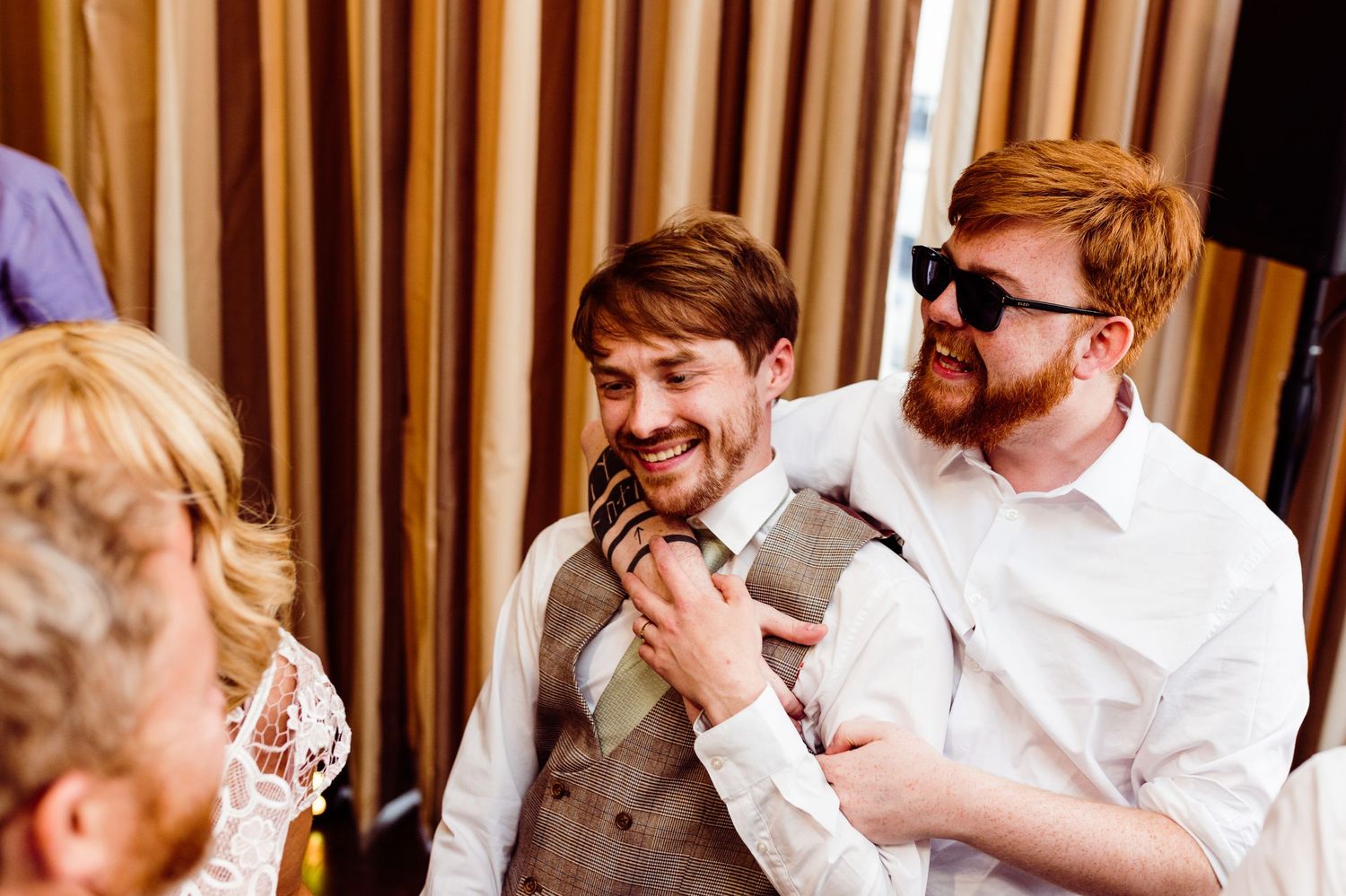Wedding guests laughing and enjoying conversations during the reception celebration.