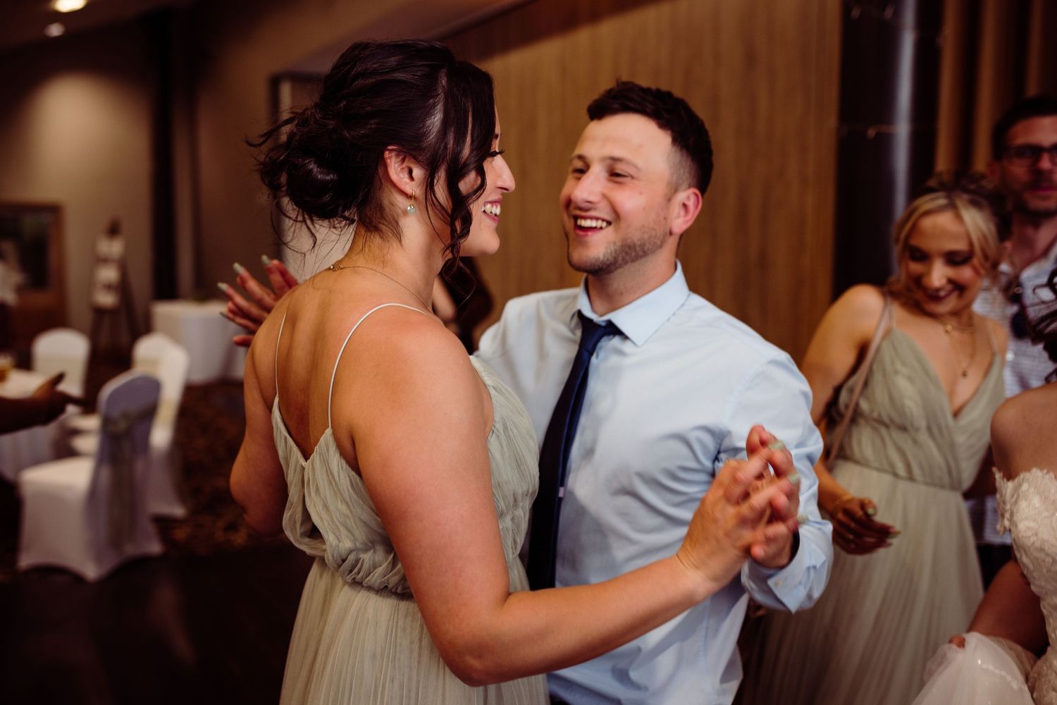 Couples dancing together during a wedding reception in an elegant venue.