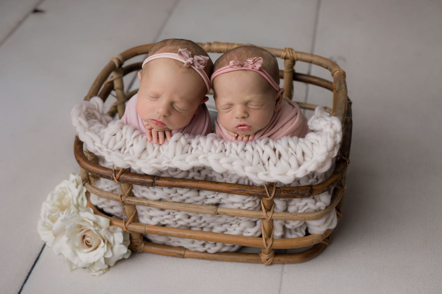 Twin newborn girls swaddled in a basket together for their studio newborn session in Scottsdale.