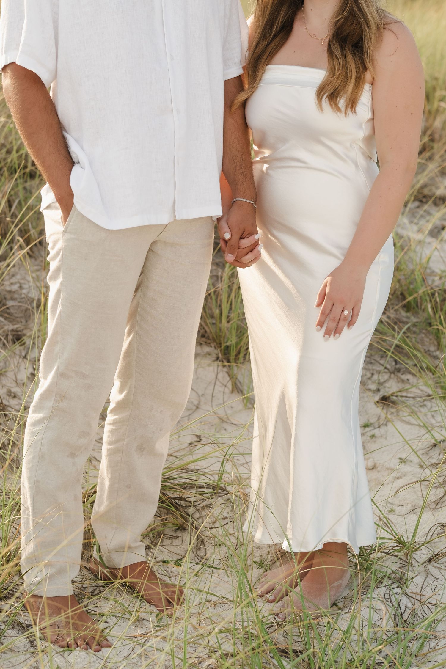 Close-up of coordinated beach outfits showing white shirt and cream dress.