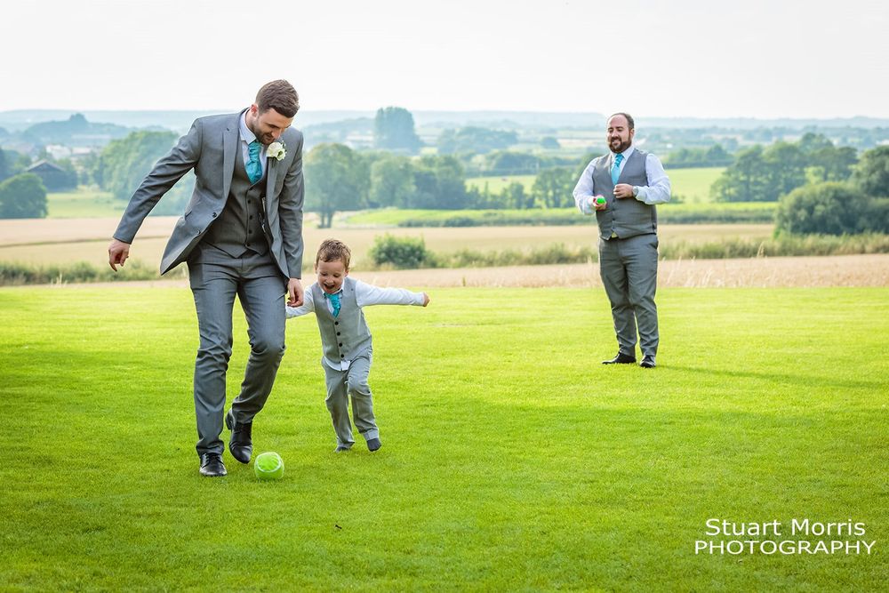 Groomsmen playing football in the gardens at west tower country house. Lancashire wedding photographer