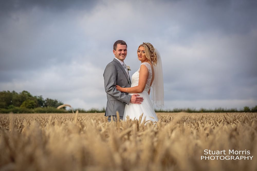 Bride and groom holding each other in the cornfields at west tower Ormskirk wedding venue.