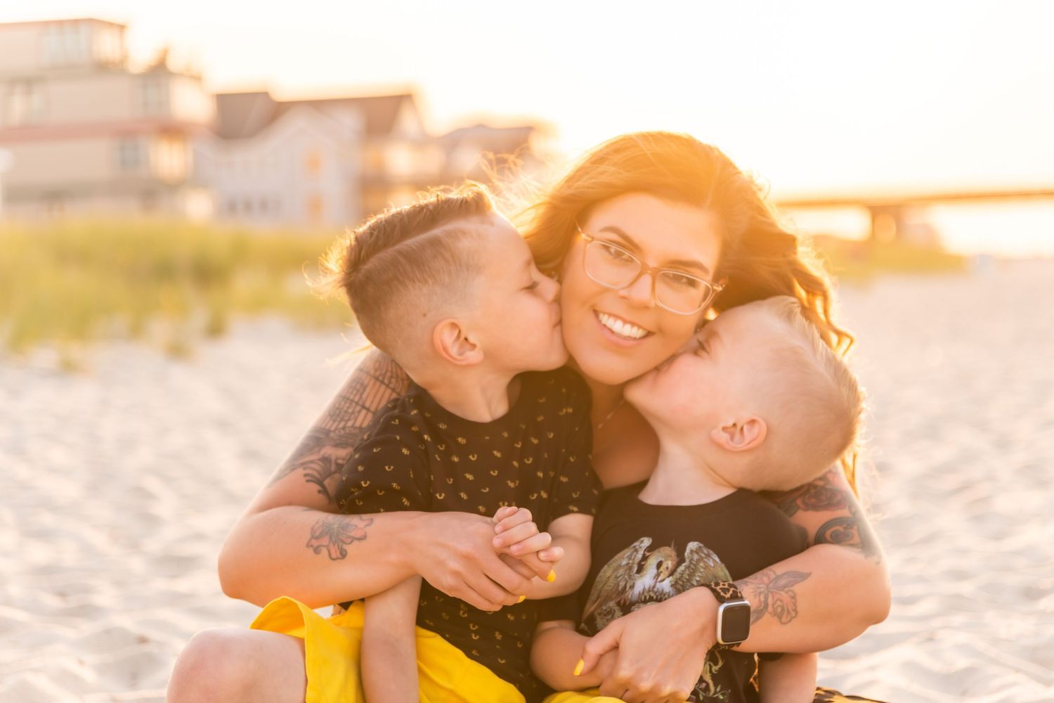 Candid sunset beach portrait of family sharing loving moment in golden light.