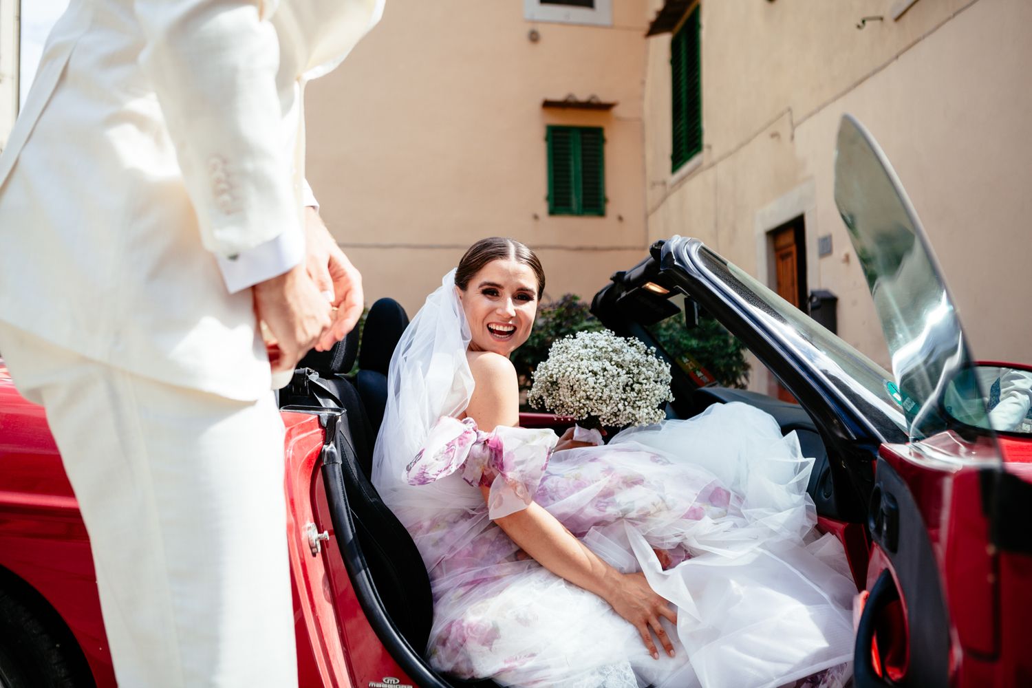bride gets into red convertible