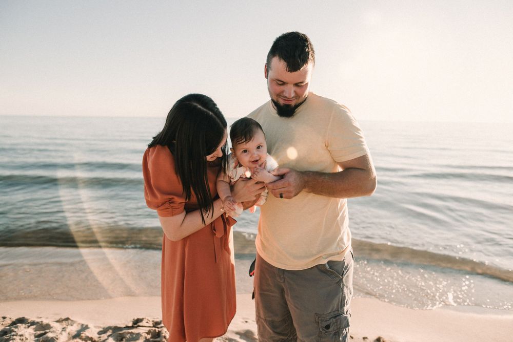Young family sharing a tender moment together on the beach.