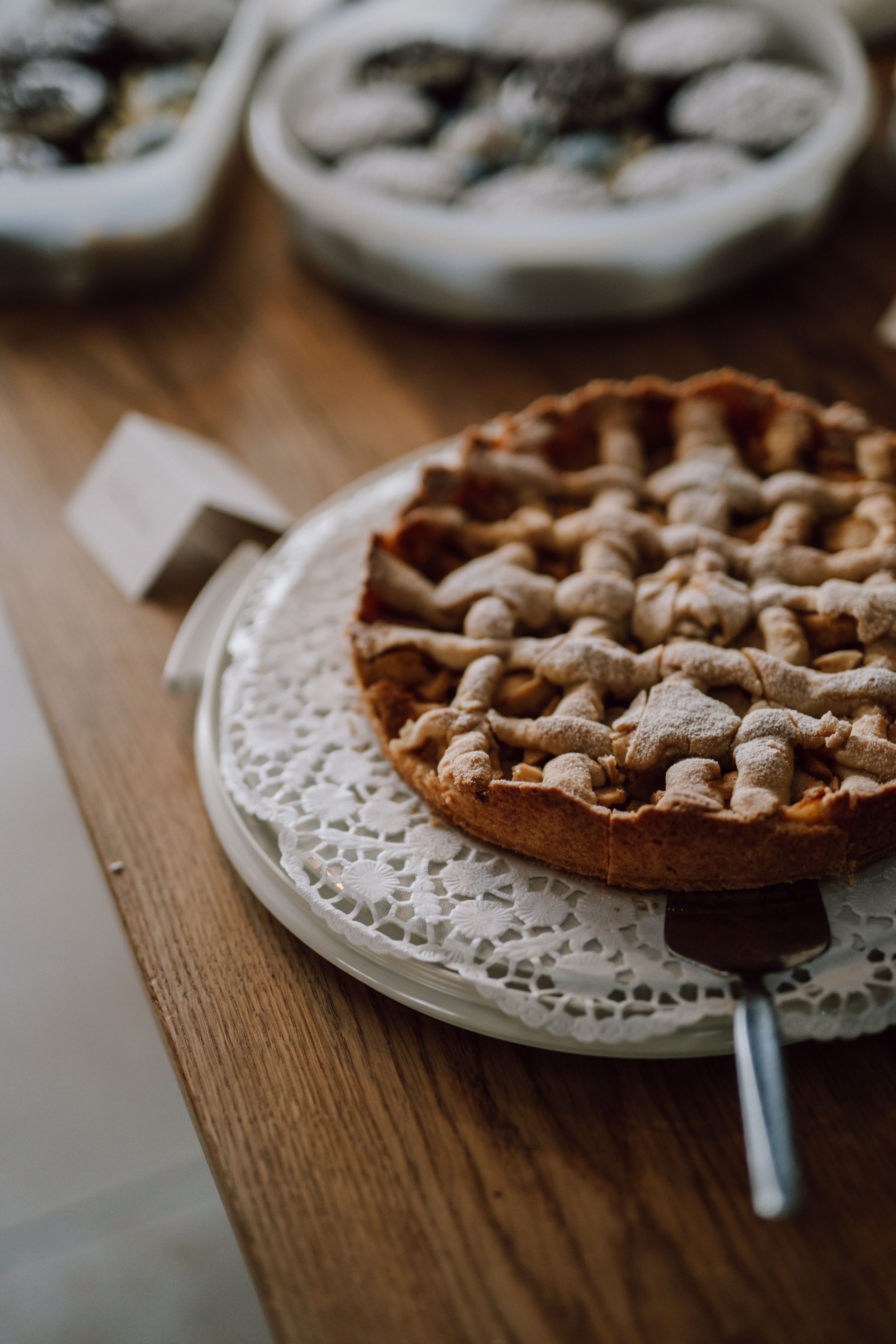 Rustic lattice pie on white doily and wooden table.