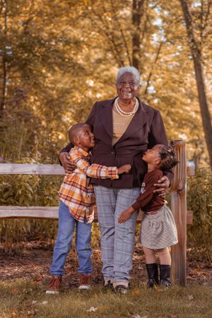 Children playing and hugging outdoors in autumn with warm golden light.