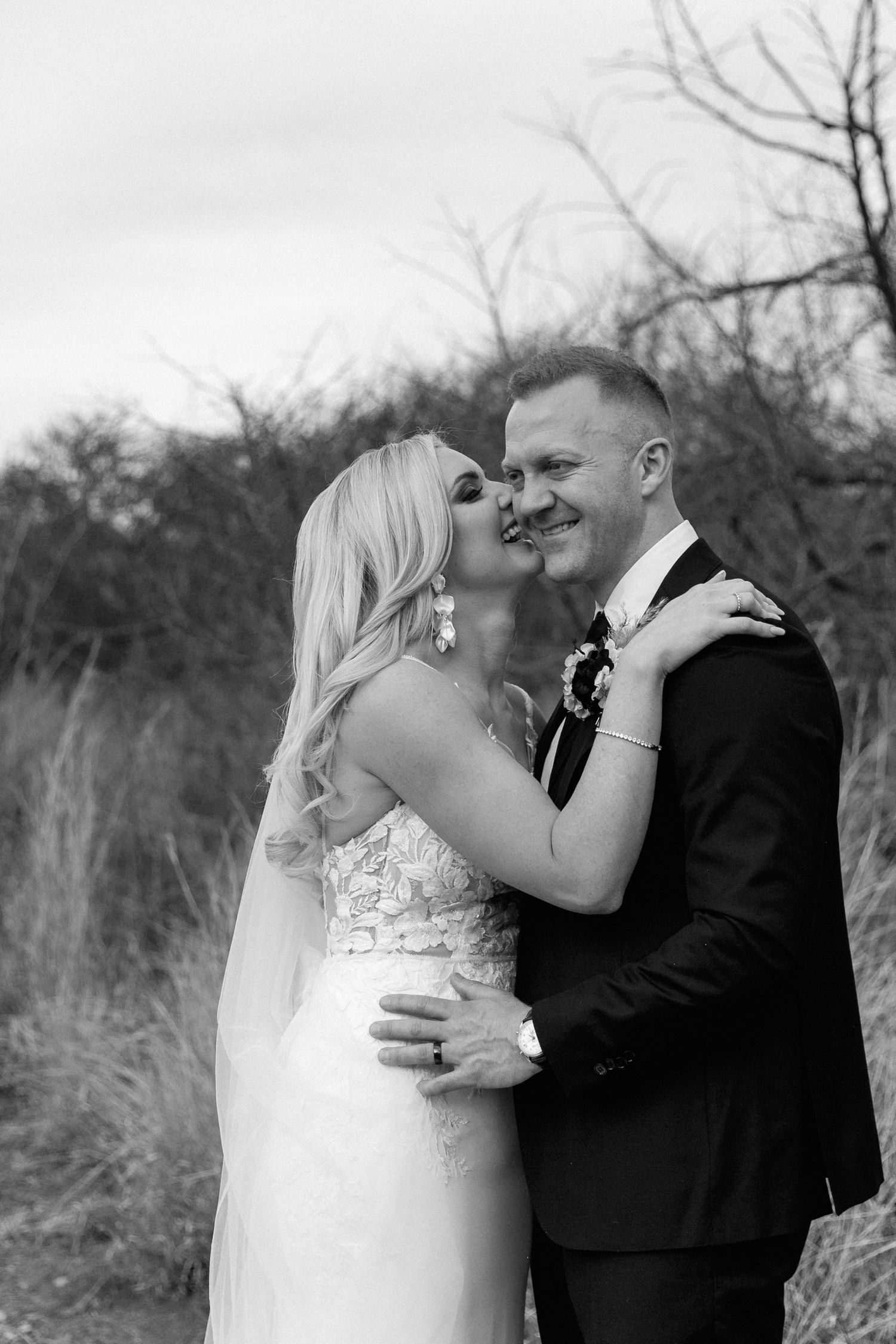 Monochrome moment of a modern wedding couple laughing.