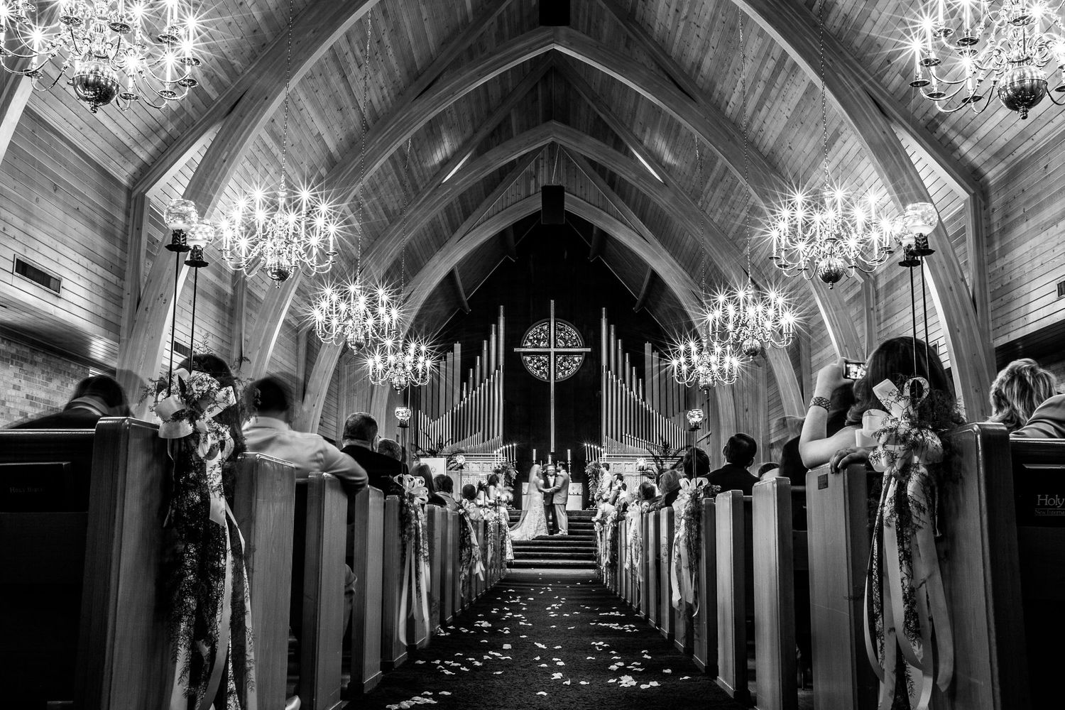 Grand church corridor with crystal chandeliers and arched ceilings.