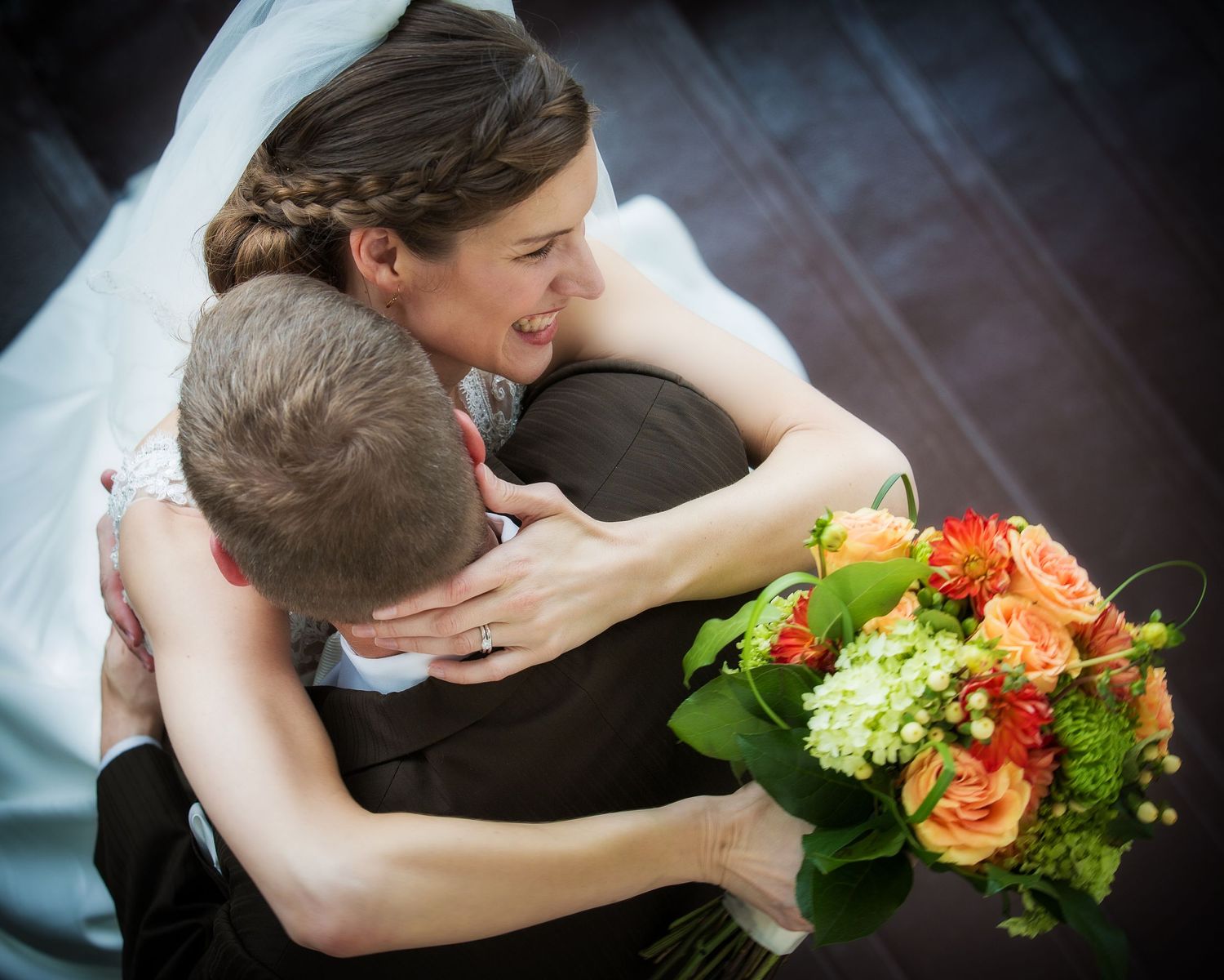 Wedding bouquets with vibrant orange and green flowers against dark background.