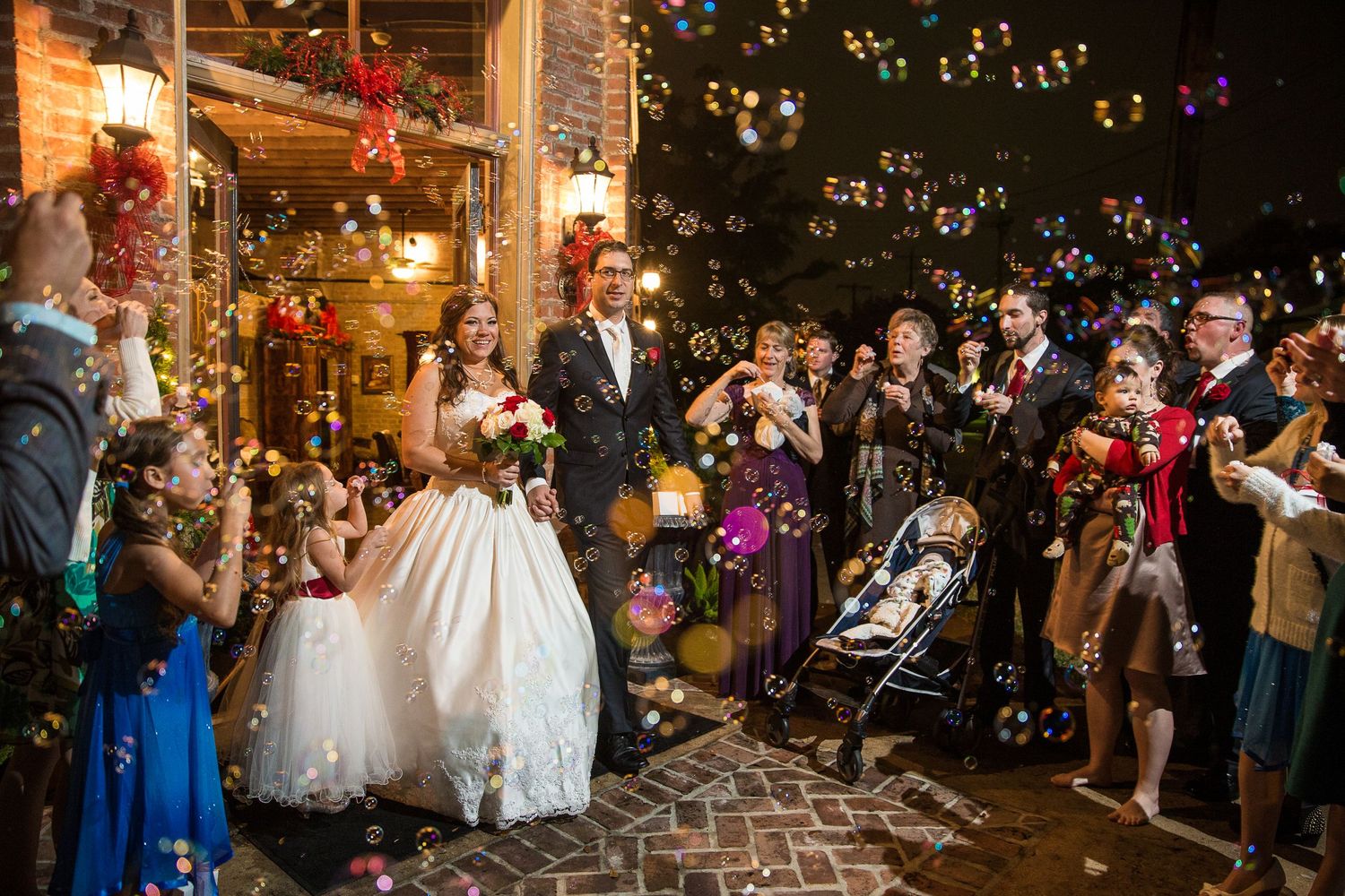 Wedding celebration at night with string lights illuminating an outdoor brick venue.