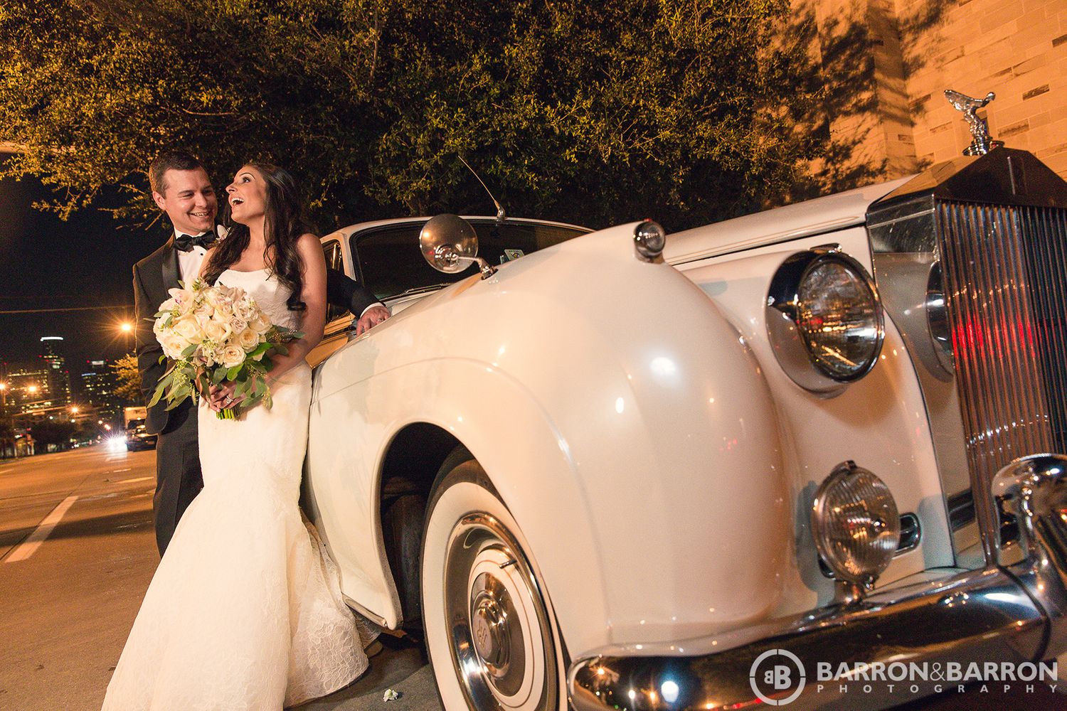 Classic white vintage car decorated with flowers and ribbons for wedding transportation.