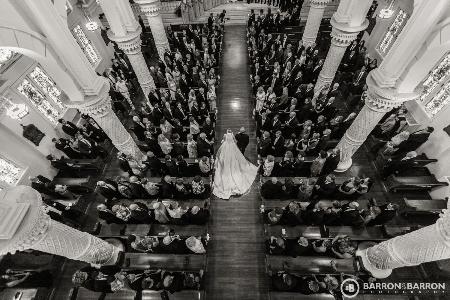 Aerial view of wedding ceremony showing guests seated in symmetrical rows from above.