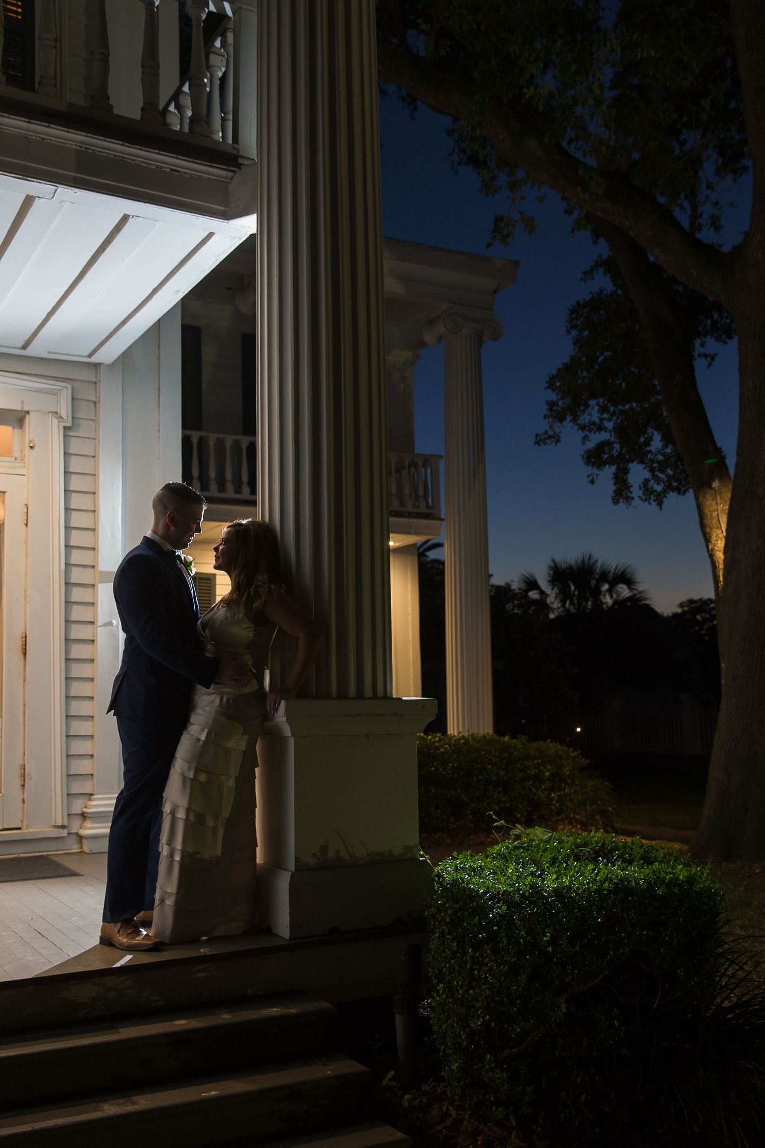 Romantic silhouettes of a couple sharing an intimate moment in a doorway at dusk.