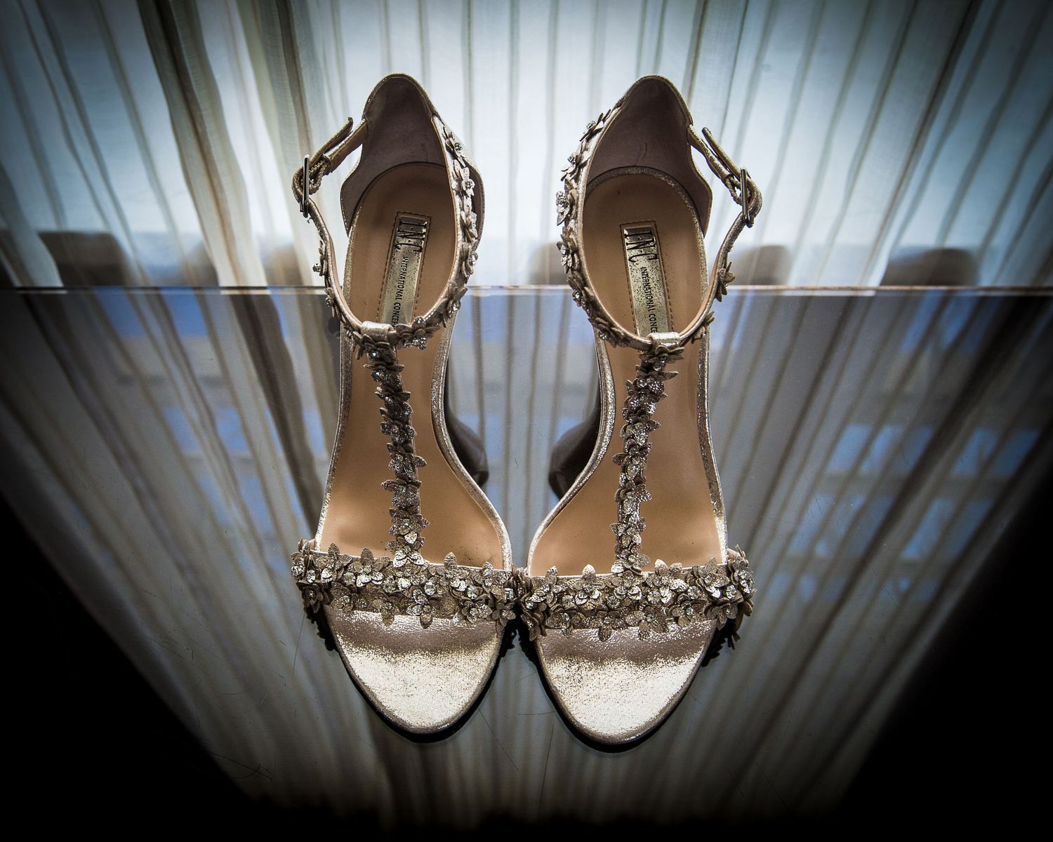 Elegant bridal shoes with crystal details displayed against white backdrop.